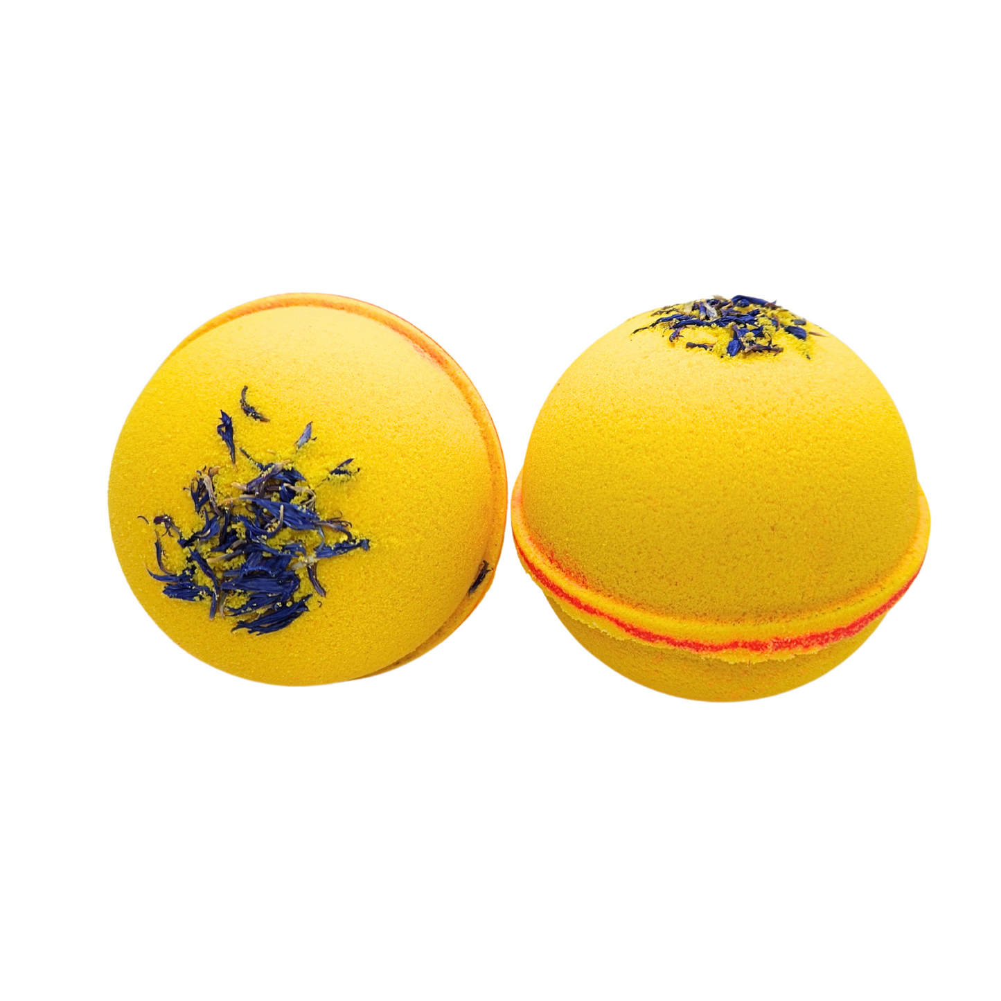 Two yellow bath bombs with orange patterns in the middle, sprinkled with blue dried flowers for decoration.