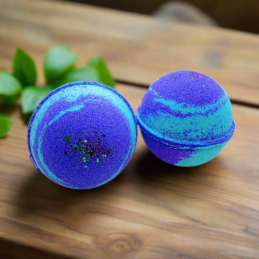 Two blue and purple bath bombs with glitter on a white background